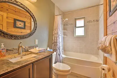 a bathroom with a tub and a toilet and a sink at 1 Mi to Granby Ranch Family-Friendly Cabin! in Granby