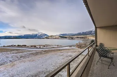 a balcony with a table and a chair overlooking a lake at 7 Mi to Keystone Resort Condo with Hot Tub and Pool in Dillon