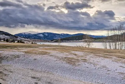 a snow covered field with a lake and mountains in the background at 7 Mi to Keystone Resort Condo with Hot Tub and Pool in Dillon