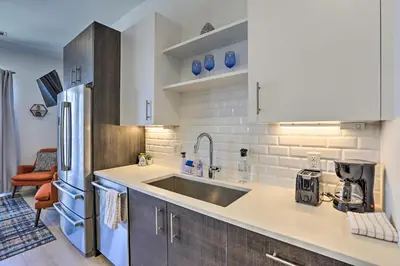 a kitchen with a sink and a refrigerator at Downtown Denver Studio Less Than 1 Mi to Coors Field! in Denver