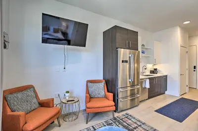 a kitchen with two chairs and a stainless steel refrigerator at Downtown Denver Studio Less Than 1 Mi to Coors Field! in Denver