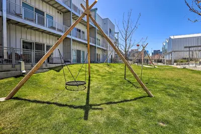 a swing set in the grass in front of a building at Downtown Denver Studio Less Than 1 Mi to Coors Field! in Denver