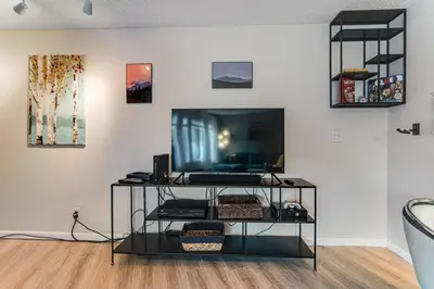 a living room with a television on a shelf at Snowblaze Studio in Winter Park