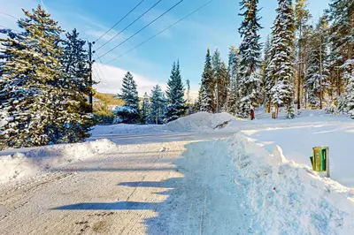 a road covered in snow with trees on the side at Snowblaze Studio in Winter Park