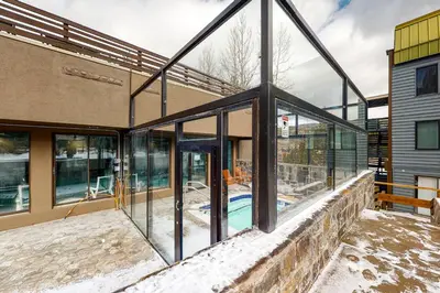 a glass house with a swimming pool in it at Snowblaze Studio in Winter Park