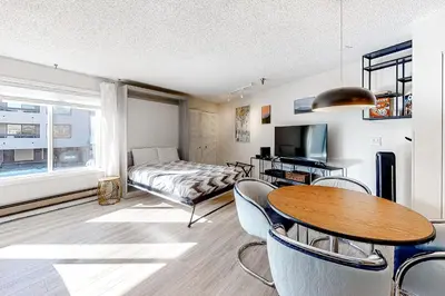a living room with a bed and a table and chairs at Snowblaze Studio in Winter Park