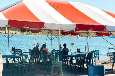 a group of people sitting at a table under an umbrella at Lake Ridge at Lake Dillon in Dillon