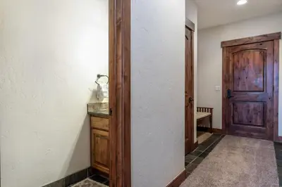 a hallway with a wooden door and a table at Rolling Ridge 20C - Wildernest in Silverthorne