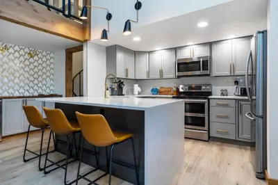 a kitchen with a large island with yellow bar stools at Wild Irishman 1027 - Keystone in Keystone