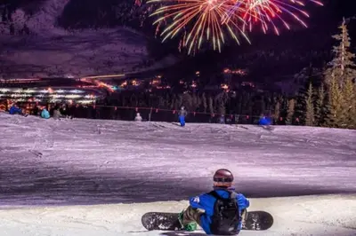 a person on a snowboard sitting in the snow with fireworks at Wild Irishman 1027 - Keystone in Keystone