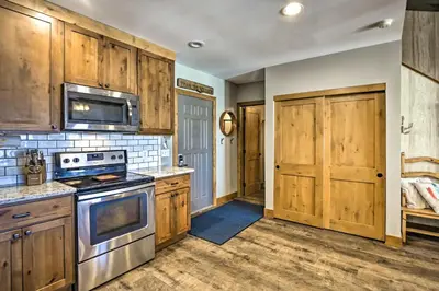 a kitchen with wooden cabinets and a stove top oven at Ski-InandSki-Out Granby Ranch Home Mountain Views! in Granby