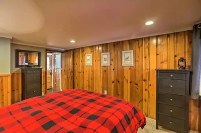 a bedroom with a red and black checkered bed at Wildmanor Ranch Near Red Rocks with Hot Tub! in Morrison