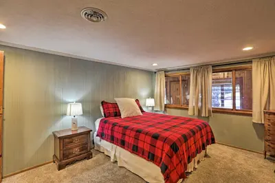 a bedroom with a bed with a red plaid blanket at Wildmanor Ranch Near Red Rocks with Hot Tub! in Morrison