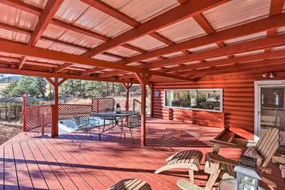 a large wooden deck with a table and chairs at Wildmanor Ranch Near Red Rocks with Hot Tub! in Morrison