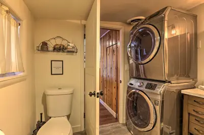a bathroom with a washing machine and a toilet at Wildmanor Ranch Near Red Rocks with Hot Tub! in Morrison