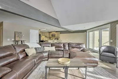 a brown leather couch in a living room with a table at Stunning Condo in Fraser with Mountain Views! in Fraser
