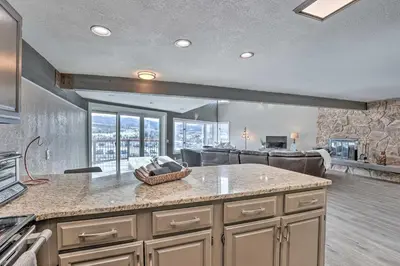 a kitchen with a counter top and a living room at Stunning Condo in Fraser with Mountain Views! in Fraser