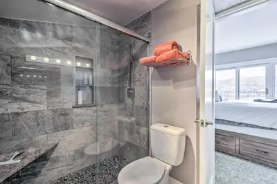 a bathroom with a shower and a toilet and a bed at Stunning Condo in Fraser with Mountain Views! in Fraser