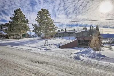 a snow covered street with a house and trees at Stunning Condo in Fraser with Mountain Views! in Fraser