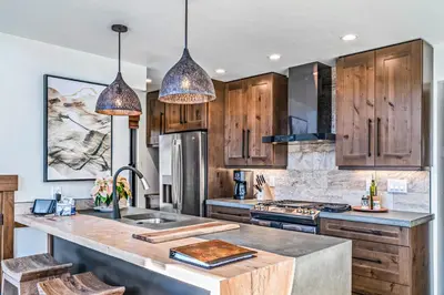 a kitchen with wooden cabinets and a sink at Indoor/Outdoor Fireplace, Jacuzzi, Heated Bathroom Floors in Estes Park