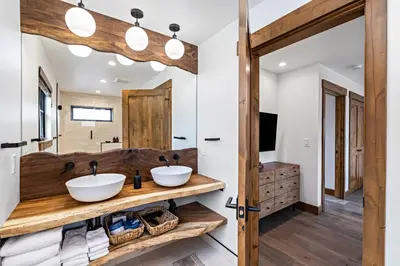 a bathroom with two sinks and a mirror at Indoor/Outdoor Fireplace, Jacuzzi, Heated Bathroom Floors in Estes Park