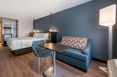 a hotel room with a bed and a blue couch at Vīb Hotel by Best Western Denver RiNo in Denver