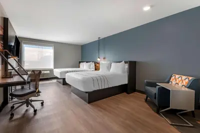 a hotel room with two beds and a desk at Vīb Hotel by Best Western Denver RiNo in Denver