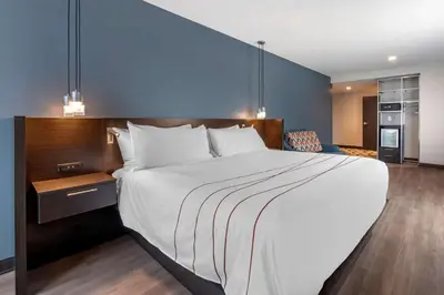 a hotel room with a large bed and a kitchen at Vīb Hotel by Best Western Denver RiNo in Denver