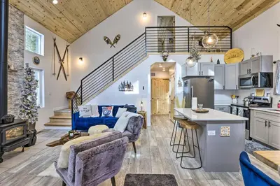 a kitchen and living room with a couch and a table at 1 Mi to St Marys Glacier Trail Modern Mtn Cabin! in Idaho Springs