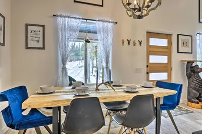 a dining room with a wooden table and blue chairs at 1 Mi to St Marys Glacier Trail Modern Mtn Cabin! in Idaho Springs