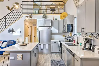 a kitchen with white cabinets and a refrigerator at 1 Mi to St Marys Glacier Trail Modern Mtn Cabin! in Idaho Springs
