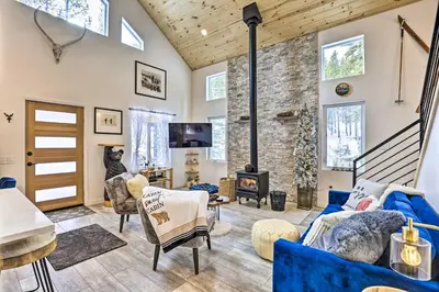 a living room with blue furniture and a fireplace at 1 Mi to St Marys Glacier Trail Modern Mtn Cabin! in Idaho Springs