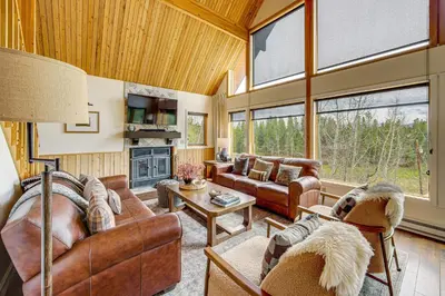 a living room with leather furniture and large windows at Dreamy Escape Btwn Winter Park and Lake Granby! in Tabernash