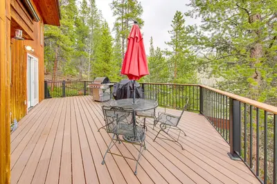 a patio with a table and an umbrella on a deck at Dreamy Escape Btwn Winter Park and Lake Granby! in Tabernash