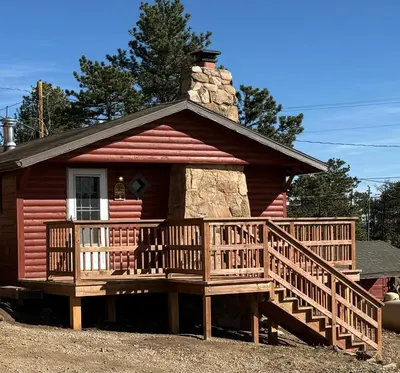 a small cabin with a large wooden deck at Marr's Mountain Cabins in Red Feather Lakes