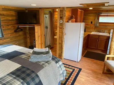 a kitchen with a white refrigerator in a log cabin at Marr's Mountain Cabins in Red Feather Lakes
