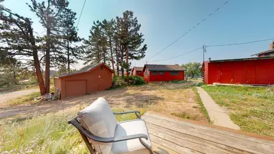 a chair sitting on a bench in a field at Marr's Mountain Cabins in Red Feather Lakes