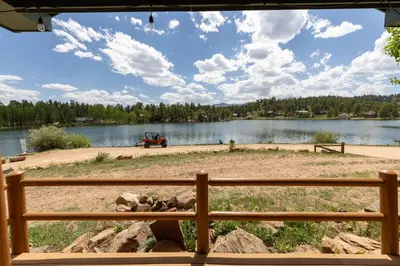 a view of a lake from a wooden fence at Marr's Mountain Cabins in Red Feather Lakes