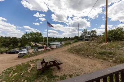 a picnic table on a dirt road with an american flag at Marr's Mountain Cabins in Red Feather Lakes