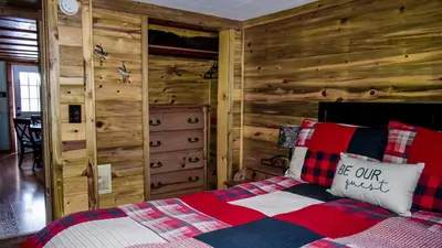 a bedroom with a bed with a wooden wall at Marr's Mountain Cabins in Red Feather Lakes