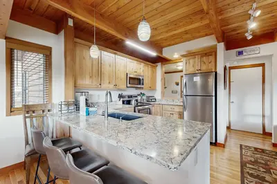 a kitchen with a counter and a refrigerator at Tennis Townhome 1312 in Keystone