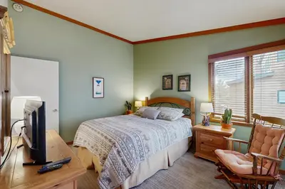 a bedroom with a bed and a tv and a chair at Tennis Townhome 1312 in Keystone