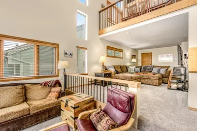 a living room with couches and a staircase at Railbender 8 in Fraser