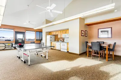 a room with a ping pong table and a kitchen at Railbender 8 in Fraser