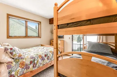a bedroom with two bunk beds and a balcony at Railbender 8 in Fraser