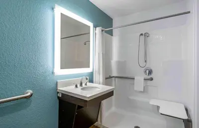 a bathroom with a sink and a shower with a mirror at Extended Stay America Select Suites - Firestone in Firestone