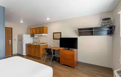 a small kitchen with a desk and a refrigerator at Extended Stay America Select Suites - Firestone in Firestone