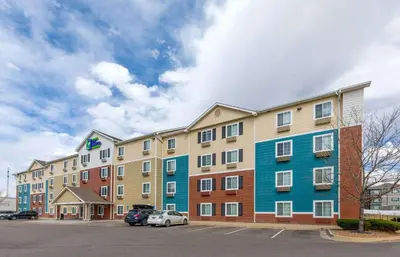 a large apartment building with a car parked in a parking lot at Extended Stay America Select Suites - Firestone in Firestone
