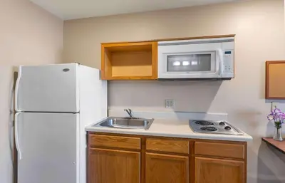 a kitchen with a white refrigerator and a sink at Extended Stay America Select Suites - Loveland in Loveland
