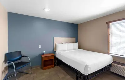 a bedroom with a bed and a chair in it at Extended Stay America Select Suites - Loveland in Loveland